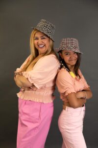 Madre e hija posan juntas con complicidad y alegría, celebrando su vínculo único en el Día de la Madre.